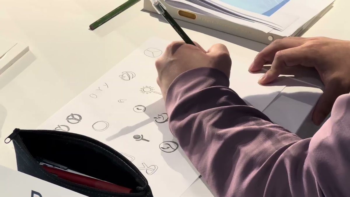 ロゴのアイデアを手描きでスケッチする受講生の手元